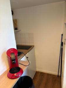 a red toaster sitting on a counter in a kitchen at Le Cocon des Géants in Toulouse