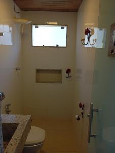 un bagno con wc e doccia con finestra di Cottage Blue palm tree nook a Itapecerica