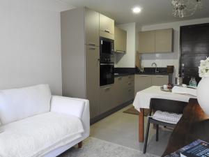 Una sala de estar con un sofá blanco y una cocina. en Cozy and relax Apartment, en Puerto Natales