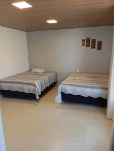 una camera con due letti in una stanza con di Cottage Blue palm tree nook a Itapecerica