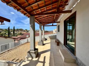 una veranda di una casa con tetto in legno di Chalé Bela Vista a Socorro