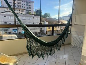 a hammock on a balcony with a view of a city at Apto centro 50m Via del Vino in Bento Gonçalves
