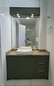 a bathroom with a sink and a mirror at Residencial Astrogildo - Perto de TUDO! LZN Hospedagens in Santa Maria