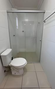 a white bathroom with a toilet and a shower at Residencial Astrogildo - Perto de TUDO! LZN Hospedagens in Santa Maria +7 photos
