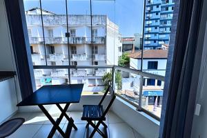 a table and chair on a balcony with a window at Residencial Astrogildo - Perto de TUDO! LZN Hospedagens in Santa Maria