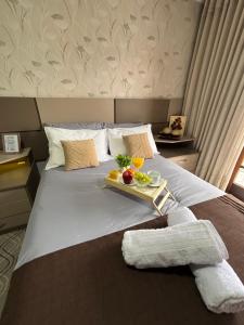 a bed with a tray of fruit on it at Casa Confortável 03 Quartos Com Suite, Churrasqueira, Banheira e Garagem in Curitiba