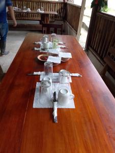 a long wooden table with plates and cups on it at Centro Turismo Comunitario Machakuyaku in Latas