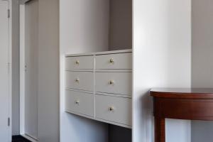 a chest of drawers in a bedroom with a table at Midtown Hotel in Boston +7 photos