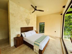 a bedroom with a bed and a ceiling fan at Nalhá Hotel Boutique y Villas in Bacalar