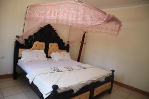 a bedroom with a bed with a canopy at Namulanda Motel in Entebbe