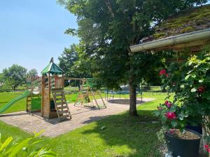 a park with a playground with a slide at Gîte des oursons - Climatisé in Guyans-Durnes