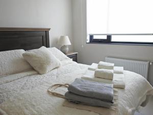 Un dormitorio con una cama blanca con toallas. en Cozy and relax Apartment, en Puerto Natales 30 fotos más