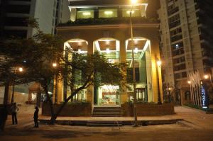纳威孟买孟买皇家郁金香酒店的一座晚上有人站在建筑前面的建筑