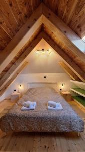 オトチャッツにあるCozy wooden house Robiniaのベッドとタオル2枚のある寝室