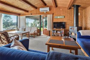 a living room with a blue couch and a fireplace at M21012-Gedser-Allingsgavevej-2 in Gedser