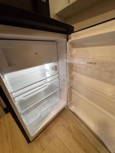 an empty refrigerator with its door open in a kitchen at Apartamenty przy parku in Elblag