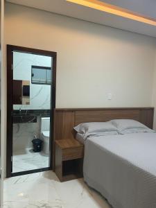 a bedroom with a bed and a large mirror at Casa Solar Beach in Vilhena +20 photos