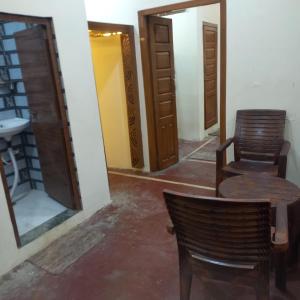 a room with two chairs and a table and a mirror at VENU NAAD BHAWAN Yatri Niwas in Mathura