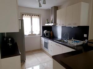 Verneuil-lʼÉtangにあるJolie et charmante maison accessible depuis Parisの白いキャビネットとシンクのあるキッチン +5枚の写真