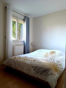 Verneuil-lʼÉtangにあるJolie et charmante maison accessible depuis Parisのベッドと窓のある寝室