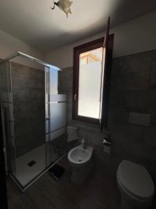 a bathroom with a toilet and a shower and a sink at Casa Arcobaleno in Ussana