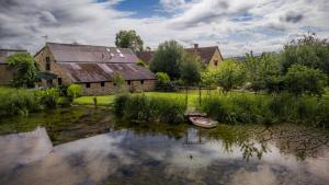 查尔德夏务农场酒店的谷仓前水中的一艘船