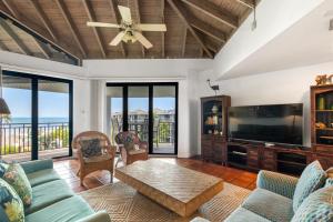 a living room with a couch and a tv at Latitude Penthouse Key West in Key West