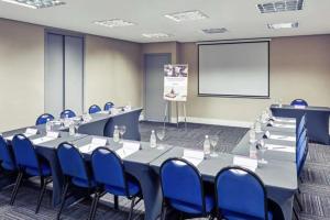 a conference room with tables and blue chairs and a screen at Lindo FLAT SP Jardins Ibirapuera com vaga inclusa in Sao Paulo +22 photos