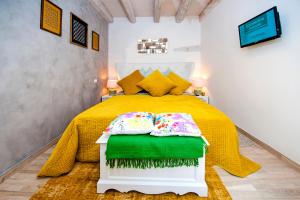 ein Schlafzimmer mit einem Bett mit gelber Tagesdecke in der Unterkunft Casa Smeralda in Rovinj