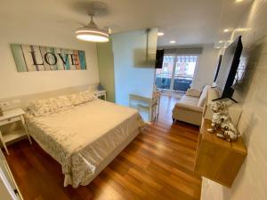 a bedroom with a bed and a desk and a couch at LOFT vistas playa jardin in Puerto de la Cruz +30 photos