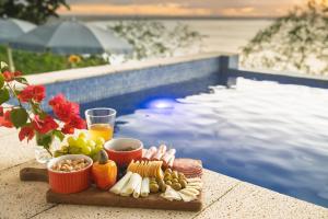 a tray of food on a table next to a swimming pool at Canto das Águas in Morro de São Paulo