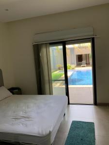 a bedroom with a bed and a sliding glass door at Appartement 2 chambres salon waterFront in Ouakam
