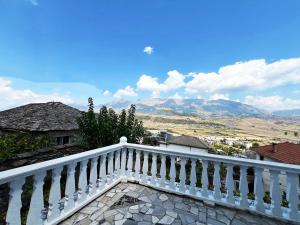 een witte leuning op een balkon met bergen op de achtergrond bij Castle Steps in Gjirokastër