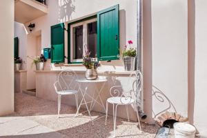 einen Tisch und Stühle auf einem Balkon mit grünen Rollläden in der Unterkunft Casa Smeralda in Rovinj
