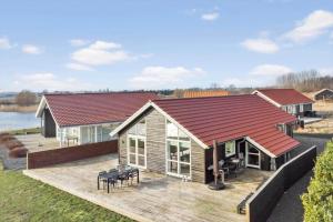 une maison avec une grande terrasse et une maison dans l'établissement M226-Vaeggerlose-Marielyst-Strandpark-253, à Bøtø By