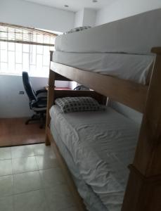 two bunk beds in a room with a chair at Alto prado 75 house in Barranquilla