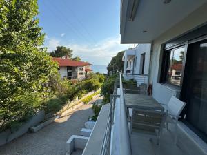 a balcony with a bench and a view of the ocean at Akti elia apartment in Kalogria