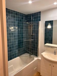 a bathroom with a tub and a toilet and a sink at Spacious 4 bedroom family home 5 min from Caen in Hérouville-Saint-Clair