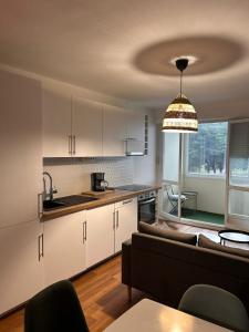 a kitchen and a living room with a couch at Spacious 4 bedroom family home 5 min from Caen in Hérouville-Saint-Clair