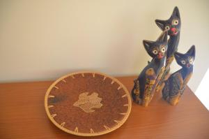 two figurines of cats sitting on a table with a medal at Taormina Bay Lucia's House Roccalumera in Roccalumera