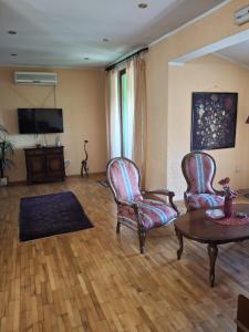 Una sala de estar con dos sillas y una mesa. en Seven Heaven, en Sremčica