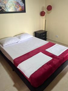 a bed with a red and white blanket on it at Romantic Glamping - Vista Impresionante Villeta Jacuzzi in Villeta