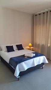 ein Schlafzimmer mit einem großen Bett mit einer blauen Decke in der Unterkunft Pousada Contemplar Tiradentes in Tiradentes