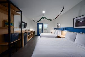 a hotel room with two beds and a tv at LOGE Missoula in Missoula