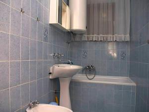 a blue tiled bathroom with a sink and a toilet at Apartments Vesna in Pinezici
