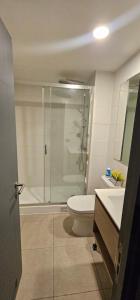 a bathroom with a shower and a toilet and a sink at Apartamento nuevo con estacionamiento in Temuco