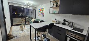 a kitchen with a counter and some bar stools at Apartamento nuevo con estacionamiento in Temuco