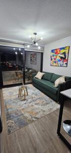 a living room with a green couch and a table at Apartamento nuevo con estacionamiento in Temuco