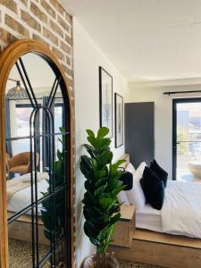 a bedroom with a bed and a mirror at Lira On White Soil in Cape Town