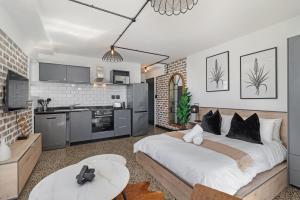a bedroom with a large bed and a kitchen at Lira On White Soil in Cape Town +13 photos